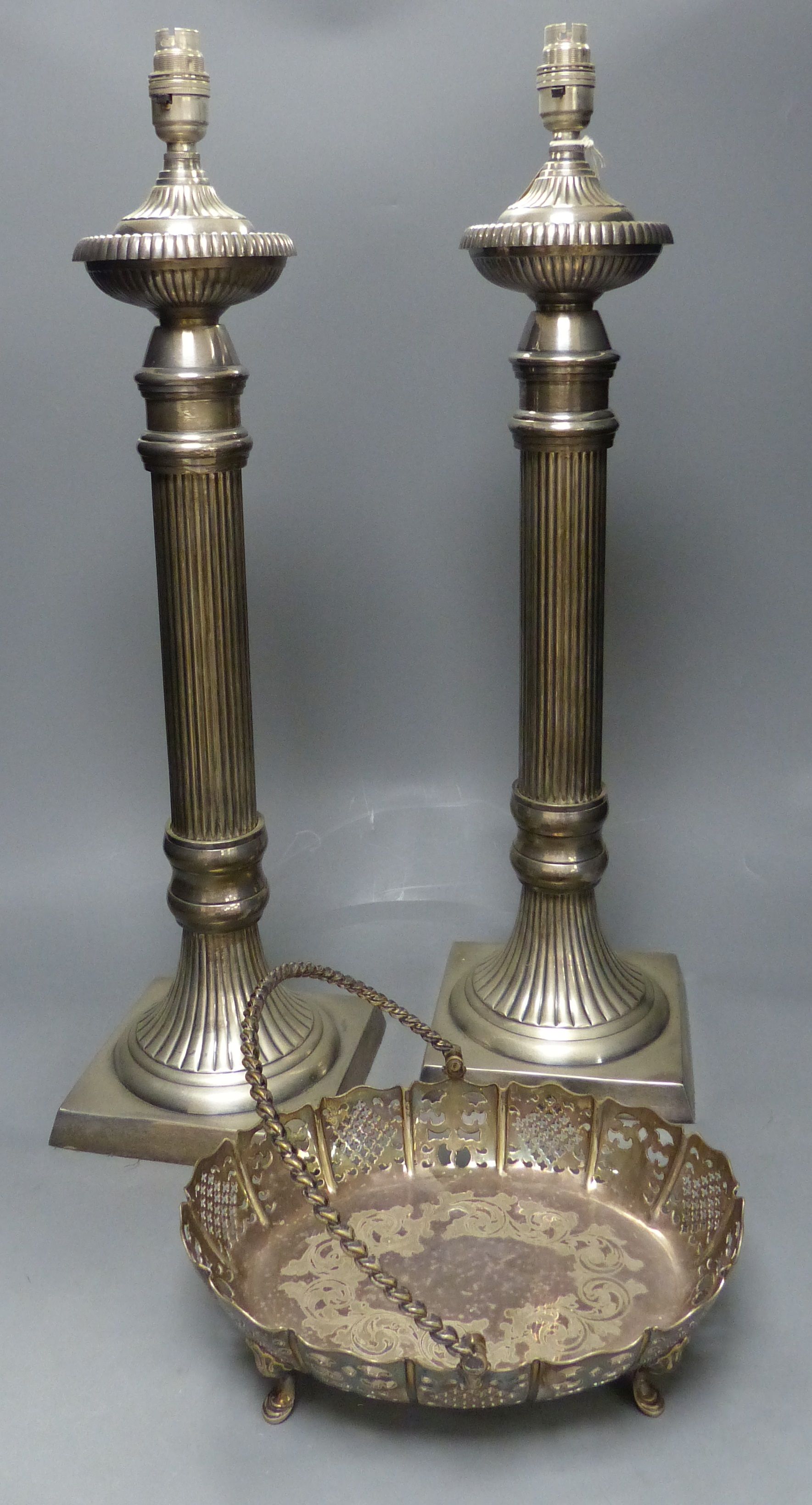 A pair of large plated electric table lamps, each square base marked AWEP, and a plated cake basket